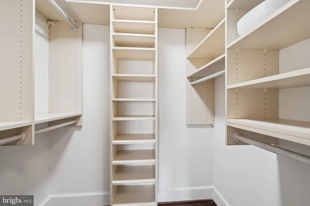 a view of walk in closet with empty racks