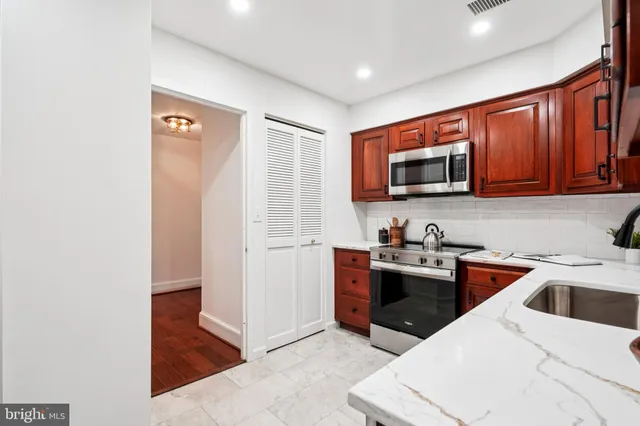 a kitchen with stainless steel appliances granite countertop a refrigerator stove and sink