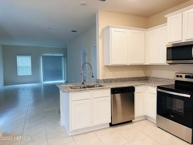 a kitchen with stainless steel appliances granite countertop a stove sink and microwave