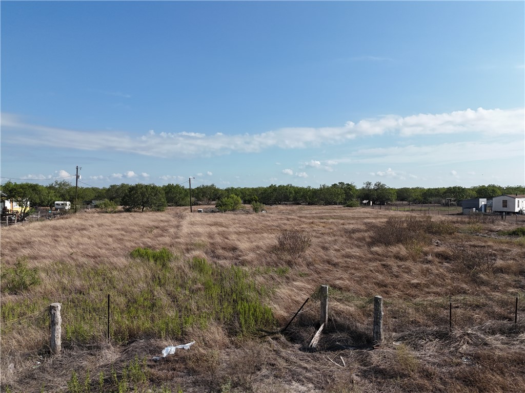 468 Jennifer Loop Orange Grove, TX 78372 - Photo 4 of 12 a view of a lake with lawn chairs and wooden fence