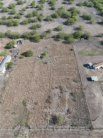 a view of a dry yard with wooden fence