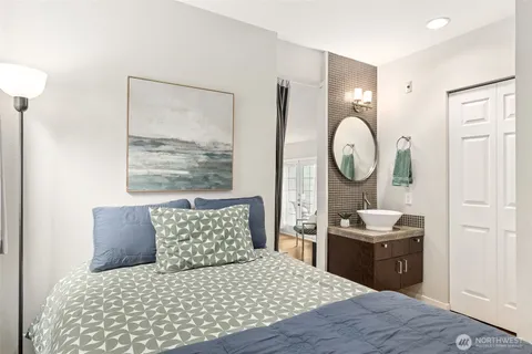 a bedroom with a large bed and a mirror