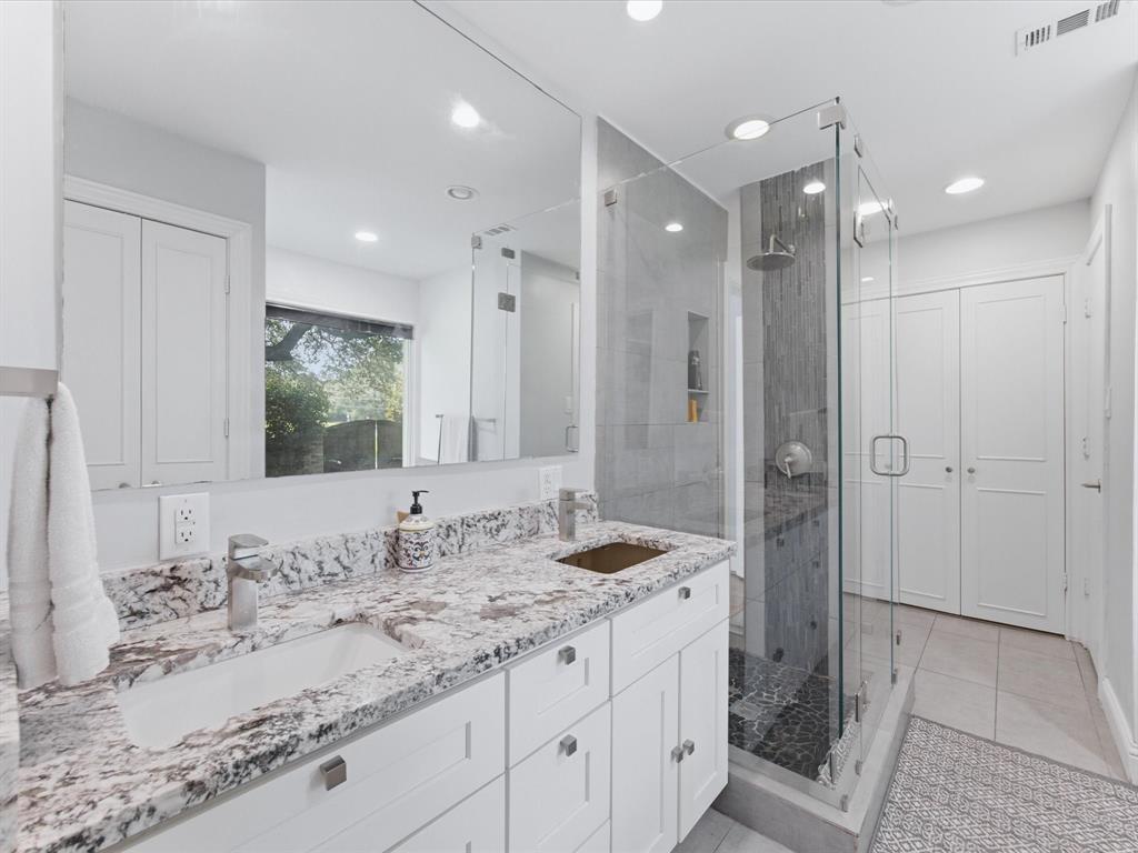 6160 Spring Valley Road Dallas, TX 75240 - Photo 29 of 40 Dual vanity with stone-finish countertop, undermount sinks, and chrome fixtures