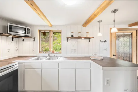 a kitchen with stainless steel appliances granite countertop a sink and a refrigerator