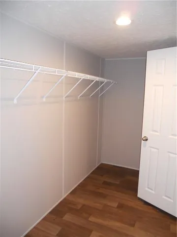 an empty room with wooden floor and entryway