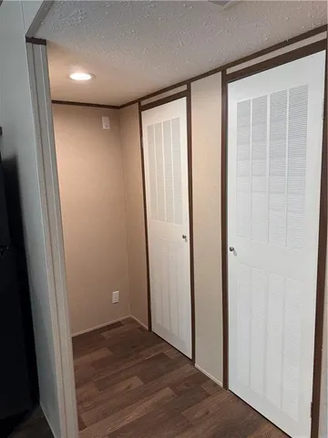 an empty room with wooden floor and entrance