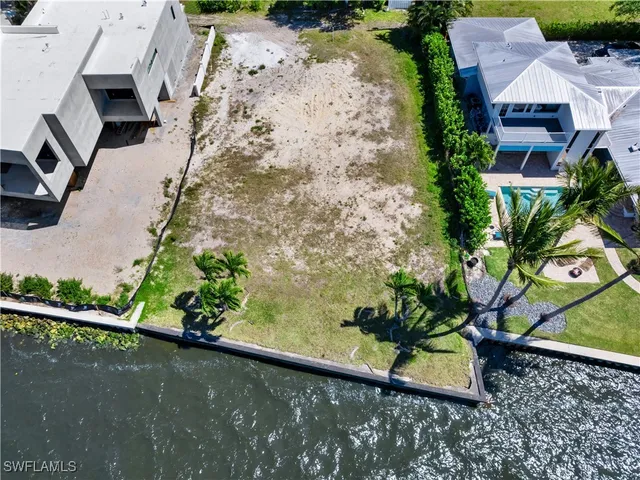 an aerial view of a house with a yard and lake view