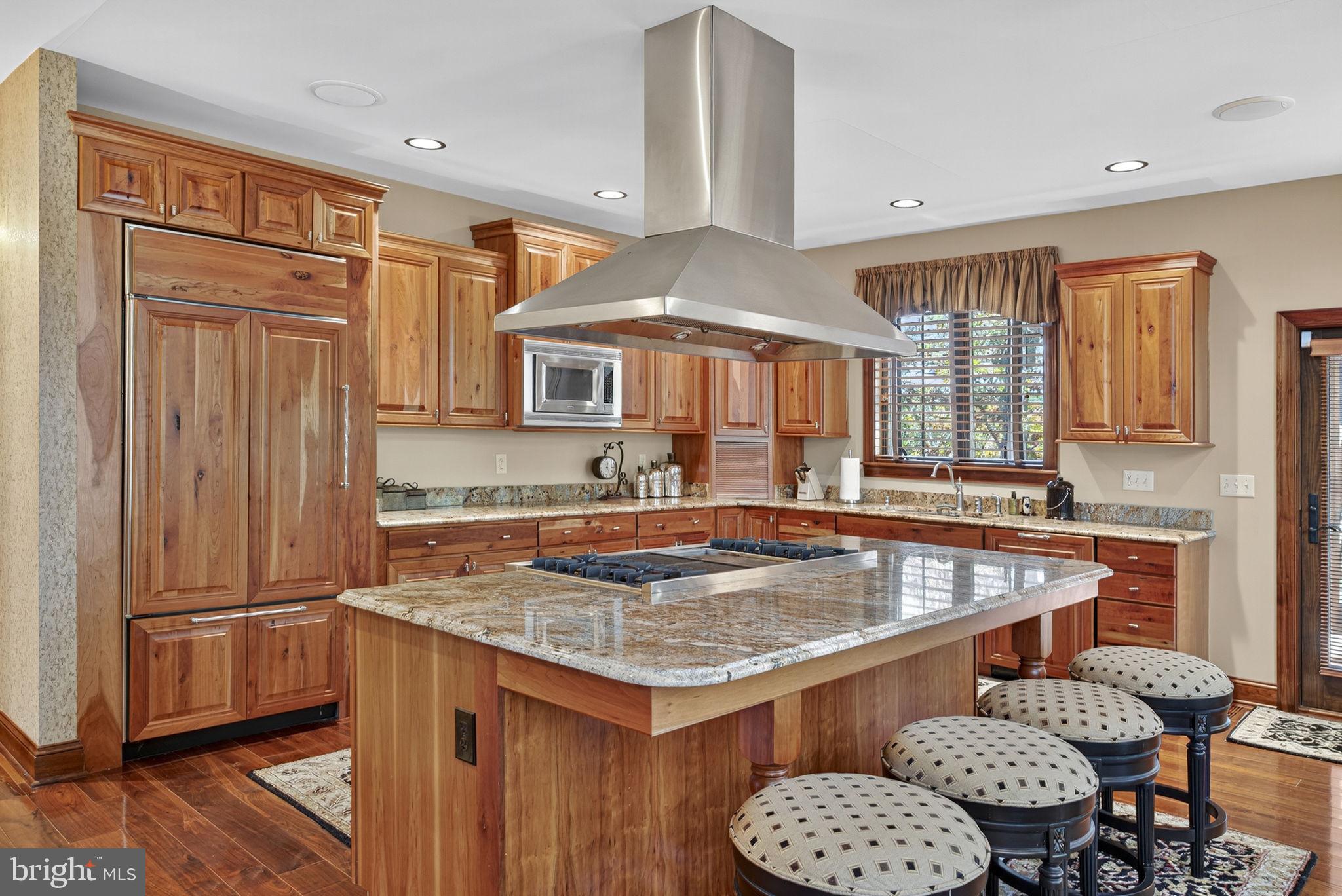 1631 Back Mountain Road Winchester, VA 22602 - Photo 14 of 86 a kitchen with granite countertop a table chairs and wooden cabinets
