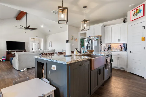 a kitchen that has a lot of cabinets in it and wooden floors