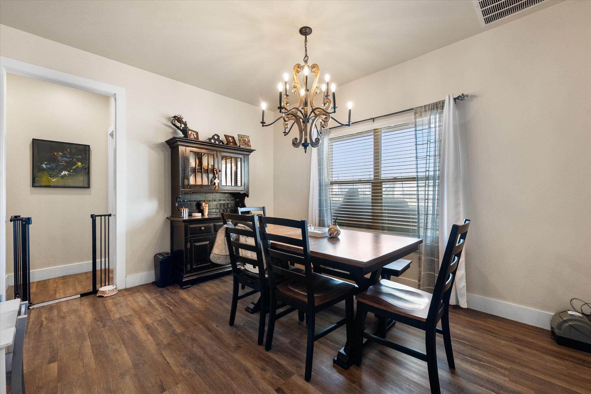 3263 Quail Road Lubbock, TX 79407 - Photo 13 of 46 a view of a dining room with furniture and wooden floor