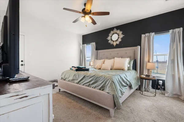 a spacious bedroom with a bed a couch and a chandelier