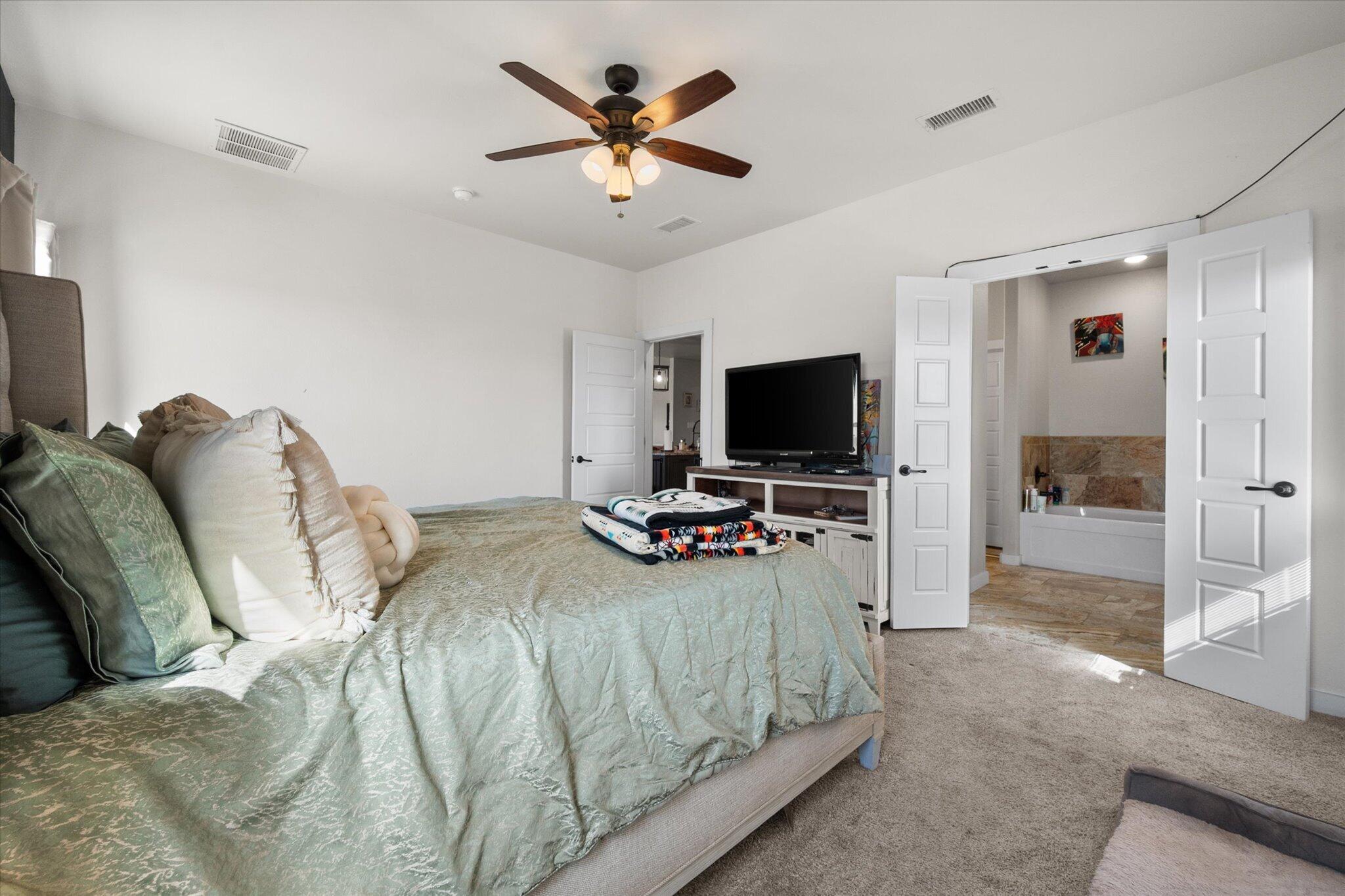 3263 Quail Road Lubbock, TX 79407 - Photo 16 of 46 a bedroom with a bed and a flat screen tv