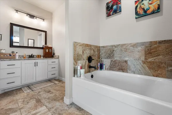 a bathroom with a bathtub sink and mirror