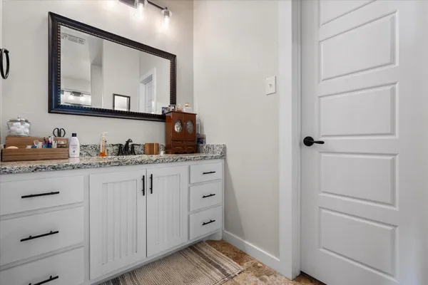 a bathroom with a granite countertop sink and a mirror