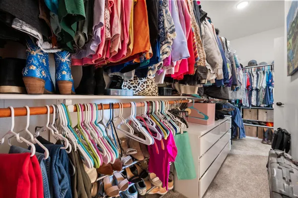 a view of walk in closet with clothes