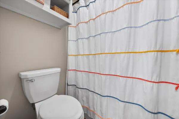 a white toilet sitting next to a shower