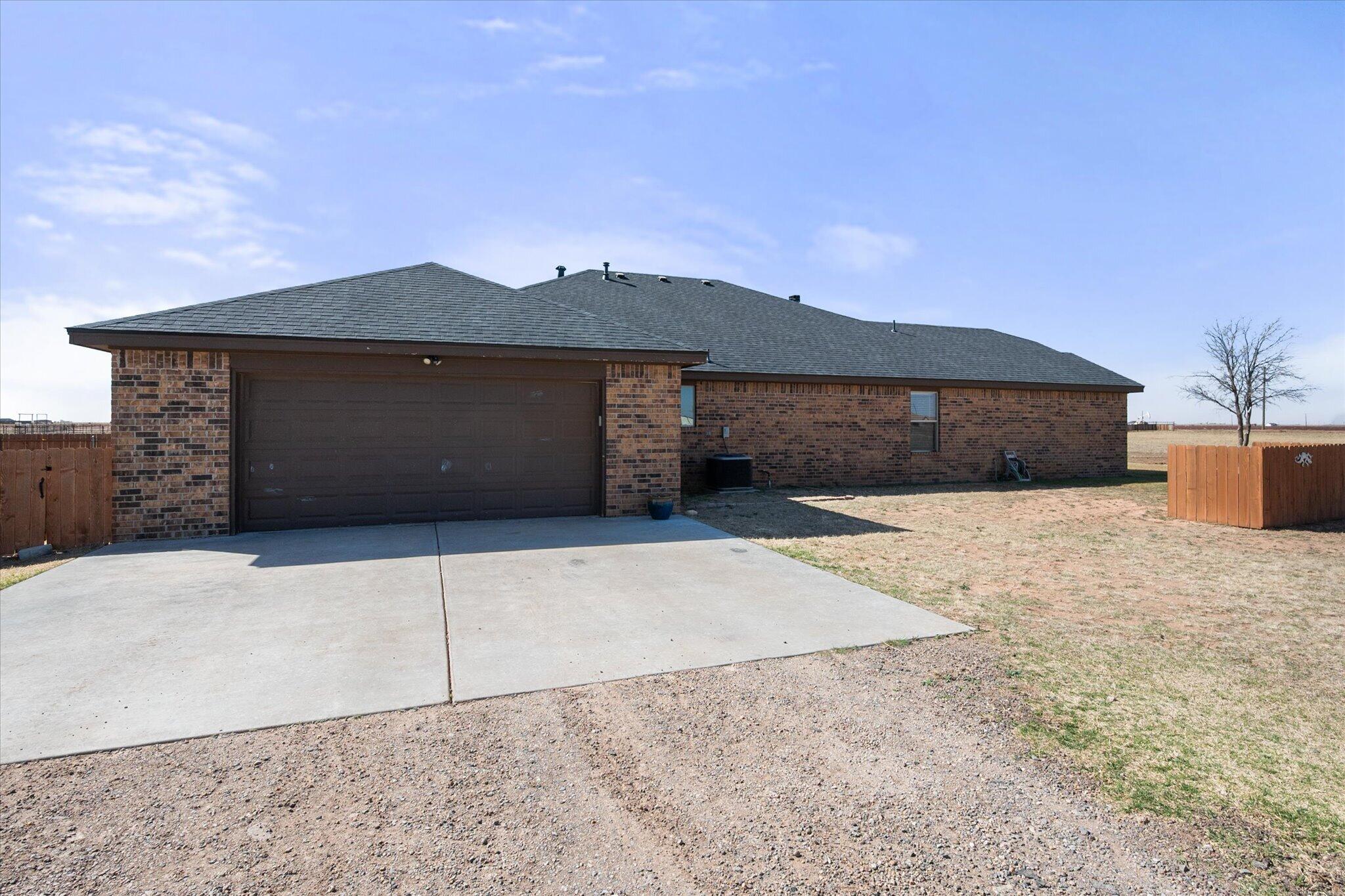 3263 Quail Road Lubbock, TX 79407 - Photo 32 of 46 a front view of a house with a yard and garage