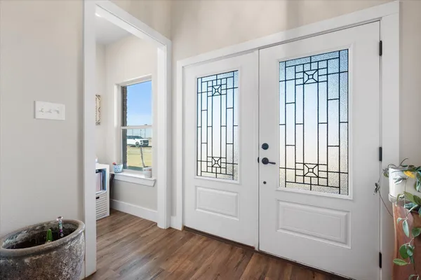 a view of a hallway with wooden floor and a livingroom