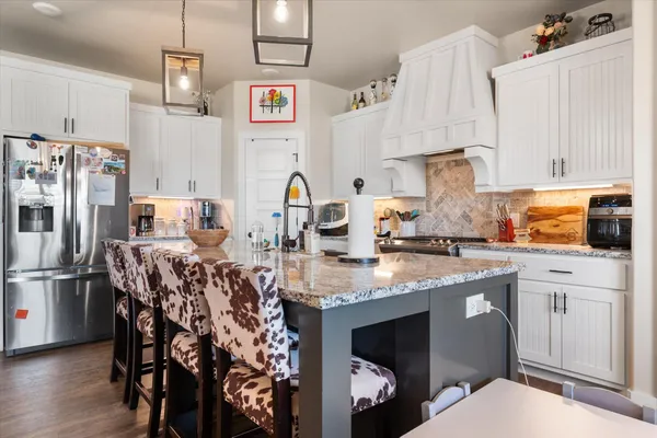 a kitchen with stainless steel appliances granite countertop a sink and a refrigerator