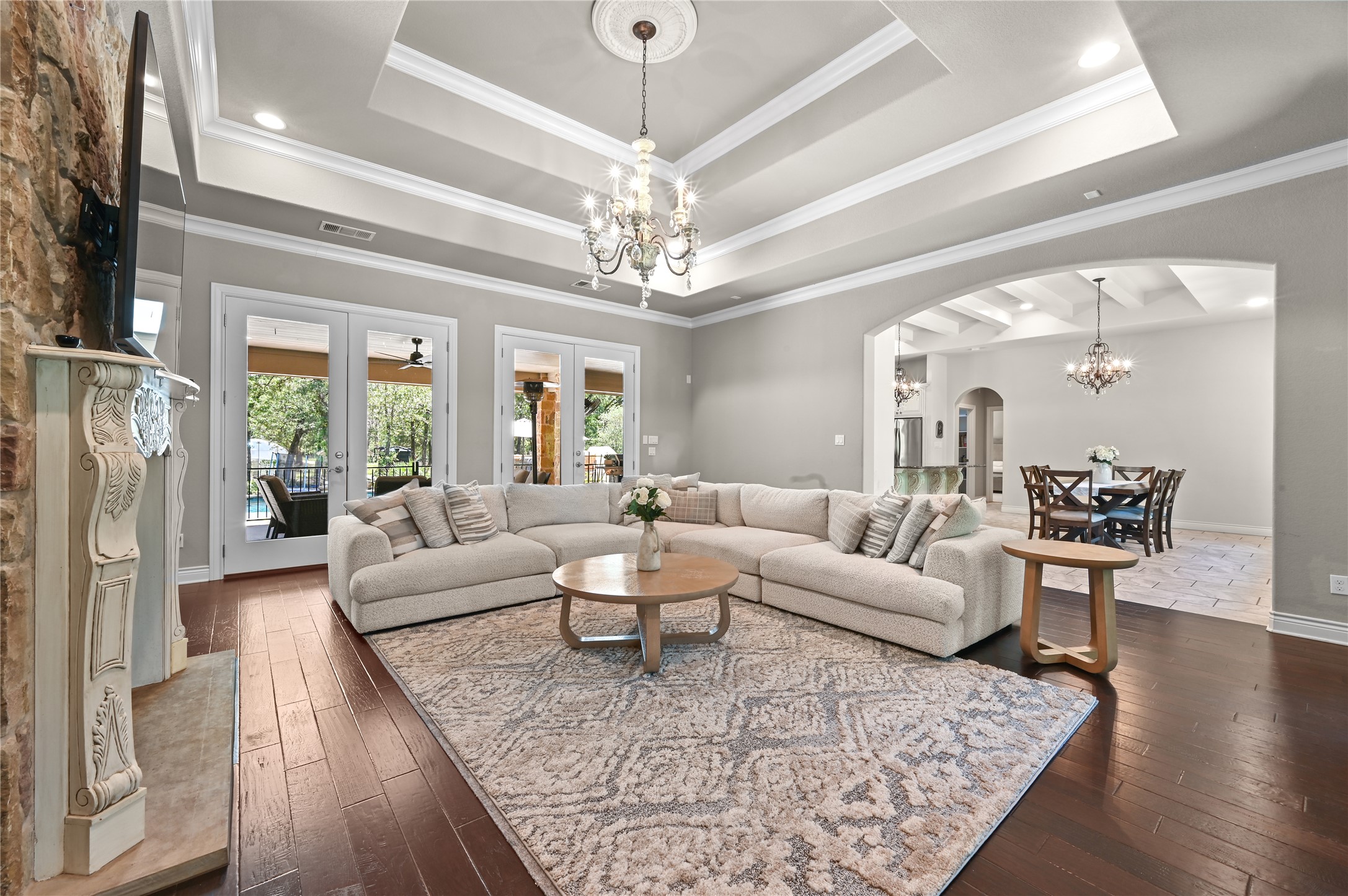 387 Corral Road Smithville, TX 78957 - Photo 11 of 40 Spacious living area featuring coffered ceilings, wood-finish flooring, and a stone-accented fireplace with an ornate mantel