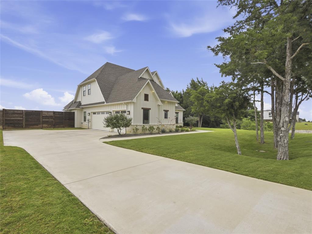 4211 Azalea Way Midlothian, TX 76065 - Photo 4 of 39 Contemporary farmhouse exterior featuring board and batten siding, stone accents, and a dark shingle roof