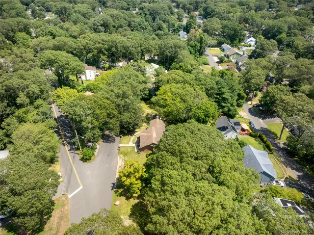 an aerial view of residential house with outdoor space and trees all around