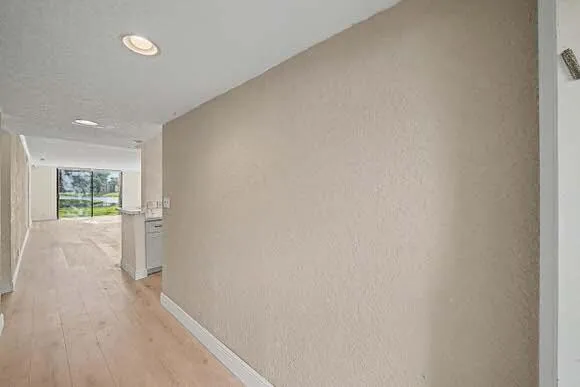 a view of an empty room with wooden floor and a balcony