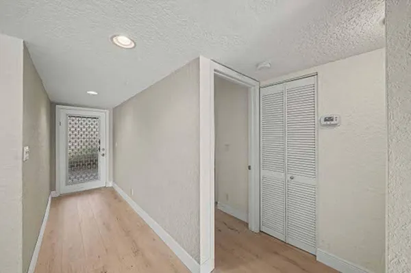 an empty room with wooden floor ceiling fan and windows