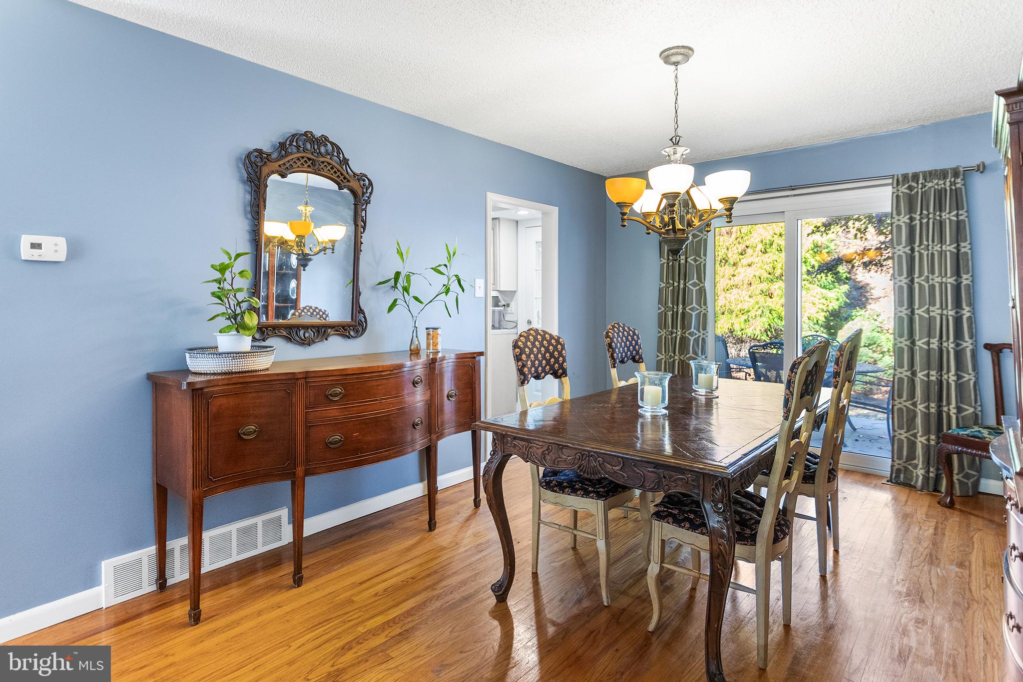 1725 Lawrence Road Havertown, PA 19083 - Photo 6 of 26 a dining room with wooden floor a chandelier a wooden table and chairs