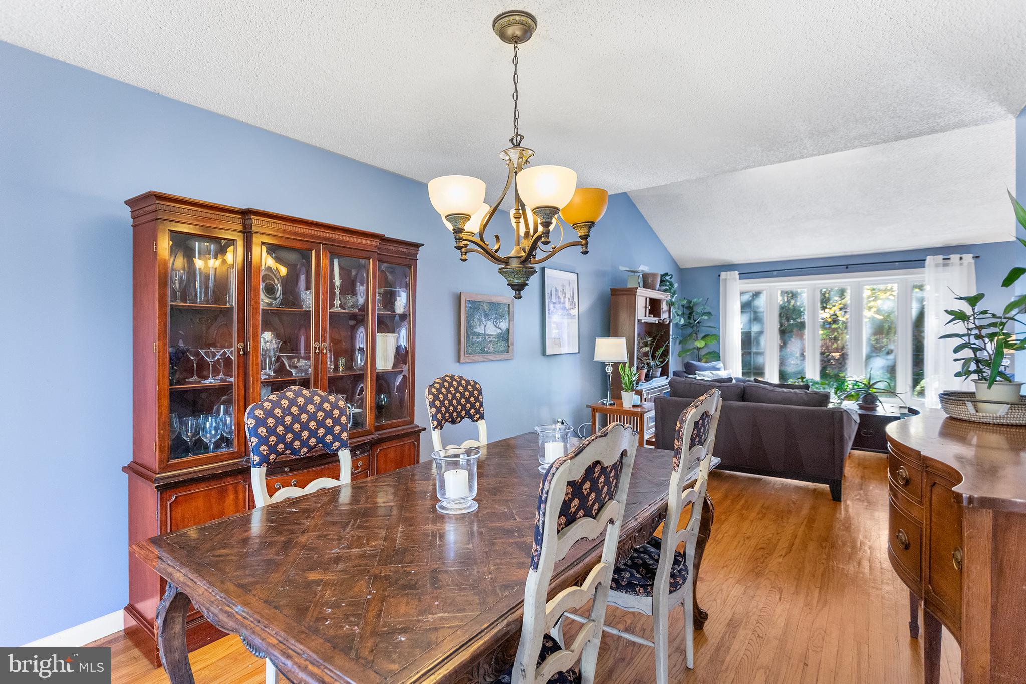 1725 Lawrence Road Havertown, PA 19083 - Photo 7 of 26 a dining room with wooden floor a chandelier a glass table and chairs