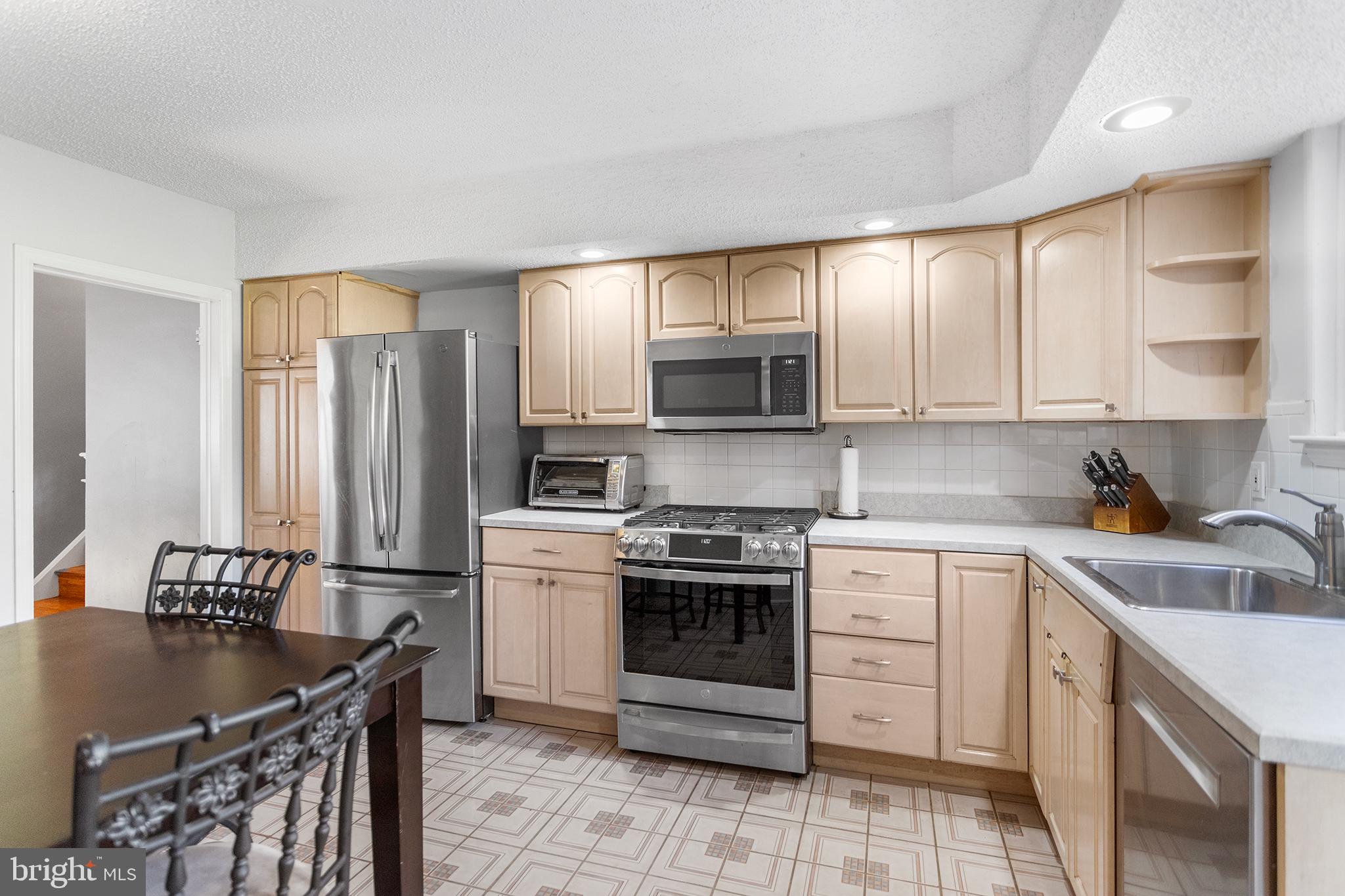1725 Lawrence Road Havertown, PA 19083 - Photo 8 of 26 a kitchen with stainless steel appliances granite countertop a sink stove refrigerator and cabinets