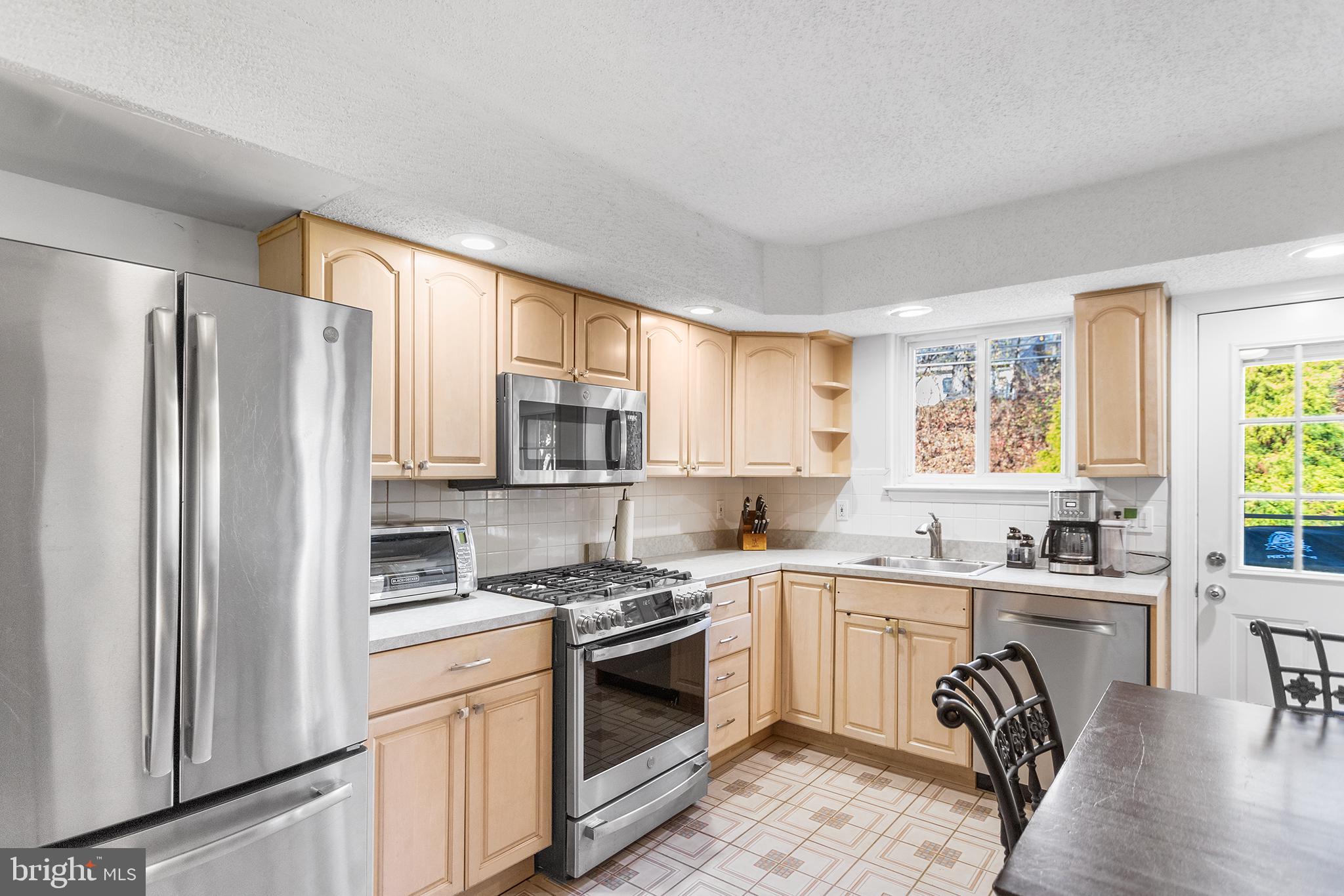 1725 Lawrence Road Havertown, PA 19083 - Photo 10 of 26 a kitchen with a refrigerator stove sink and cabinets