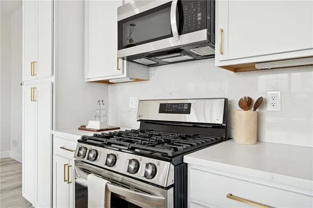a stove top oven sitting inside of a kitchen