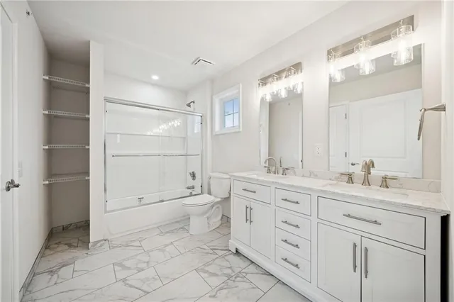 a spacious bathroom with a granite countertop sink a toilet and a mirror