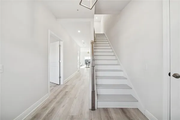 a view of a hallway with wooden floor and entryway