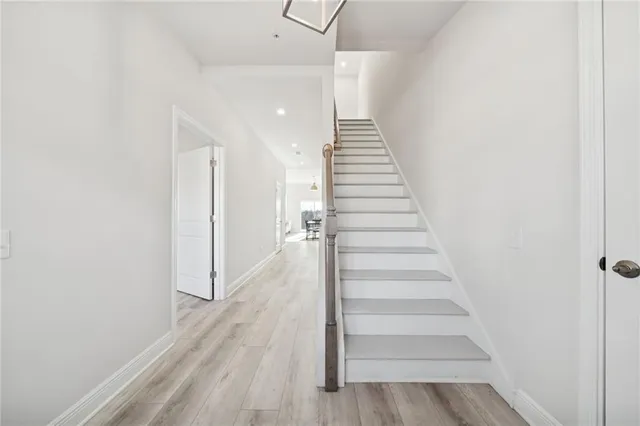 a view of a hallway with wooden floor and entryway