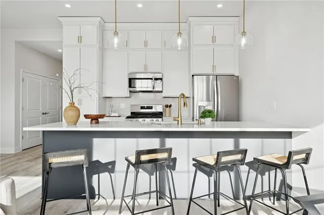 a kitchen with stainless steel appliances a table and chairs in it
