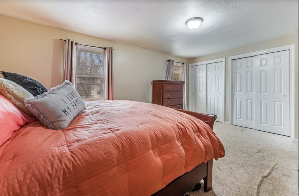 105 Irving Road, Unit 105 Randolph, MA 02368 - Photo 12 of 17 a bed sitting in a bedroom next to a window