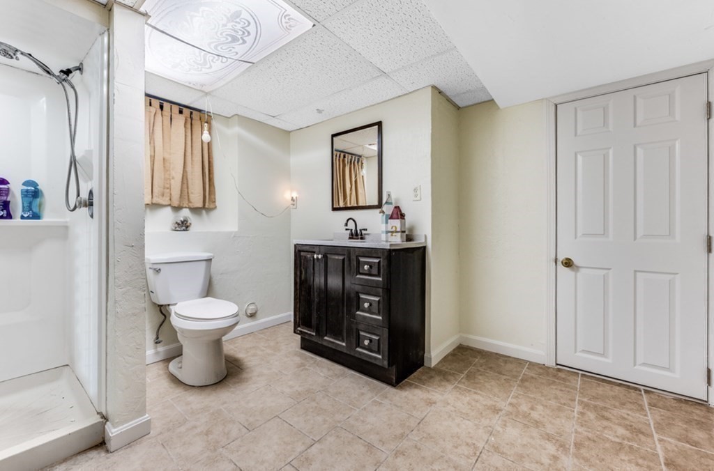 105 Irving Road, Unit 105 Randolph, MA 02368 - Photo 14 of 17 a bathroom with a toilet sink and mirror