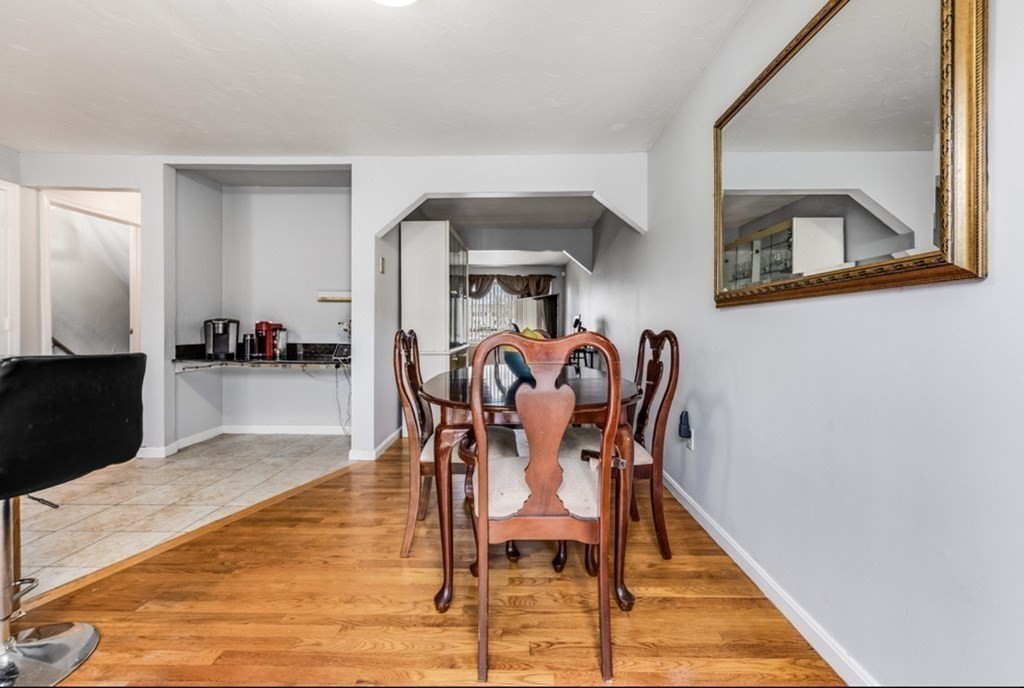 105 Irving Road, Unit 105 Randolph, MA 02368 - Photo 6 of 17 a dining room with furniture and wooden floor