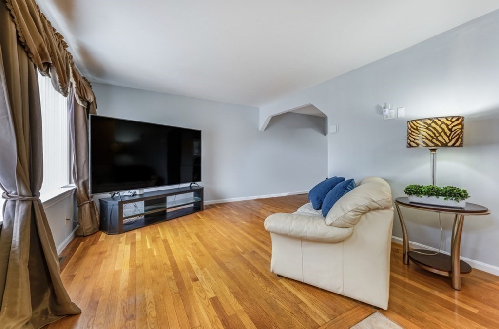 105 Irving Road, Unit 105 Randolph, MA 02368 - Photo 8 of 17 a living room with furniture and a flat screen tv