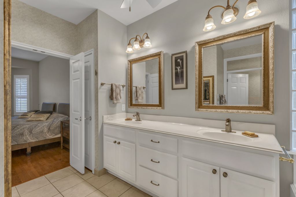 144 Cattle Trail Way Georgetown, TX 78633 - Photo 17 of 37 Elegant primary bathroom vanity with dual sinks and rich wood framed mirrors.