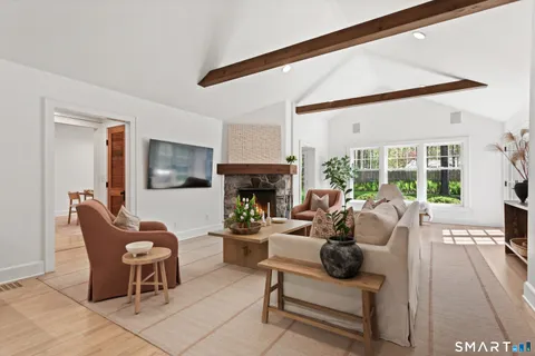 a living room with furniture a fireplace and a floor to ceiling window