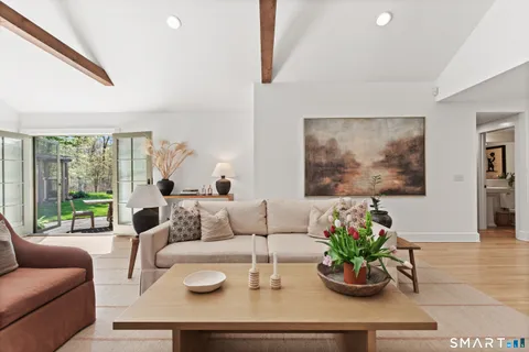 a living room with furniture potted plant and a large window