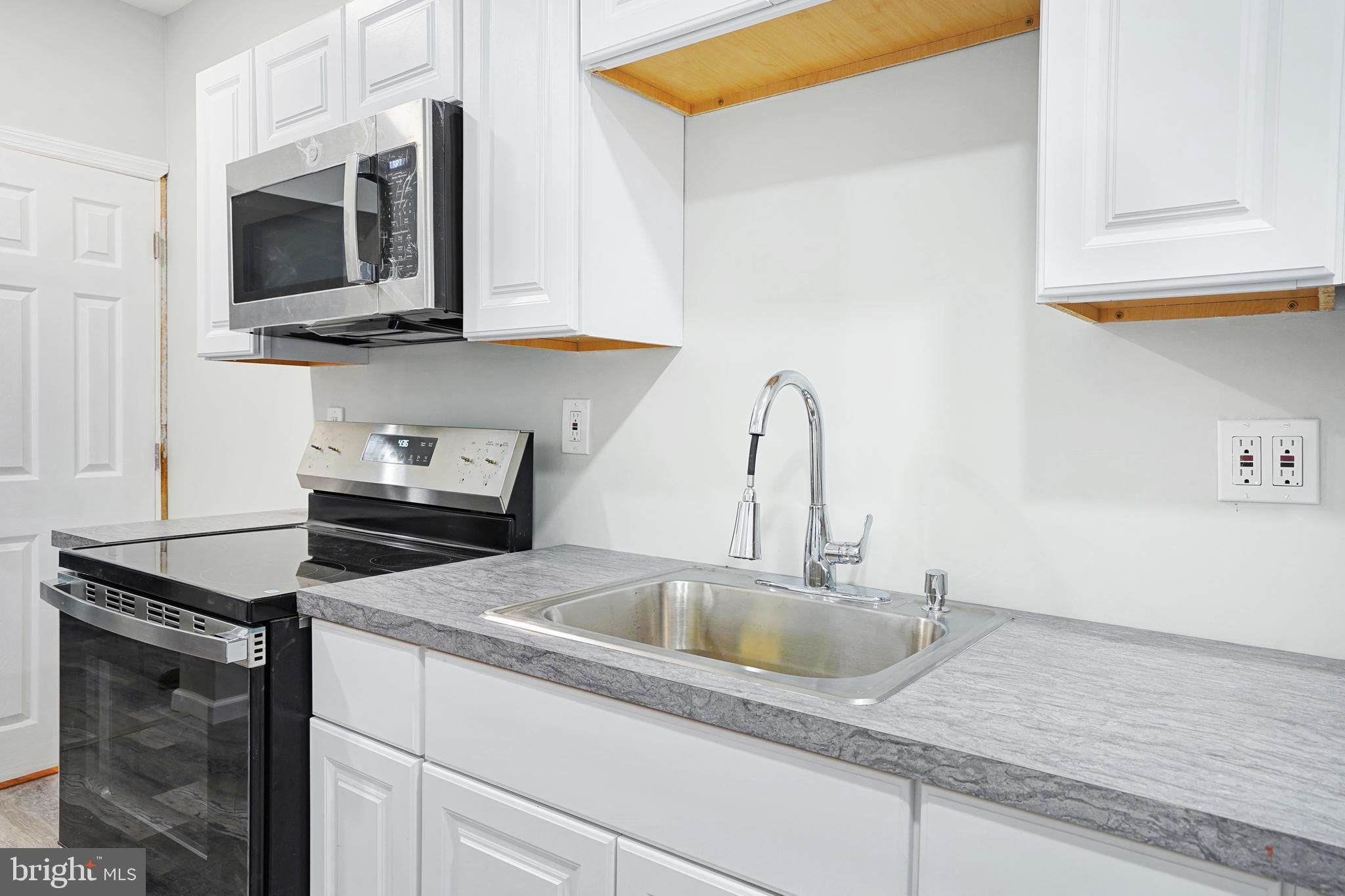565 Line Street Camden, NJ 08103 - Photo 11 of 31 a kitchen with stainless steel appliances granite countertop a sink a microwave and cabinets