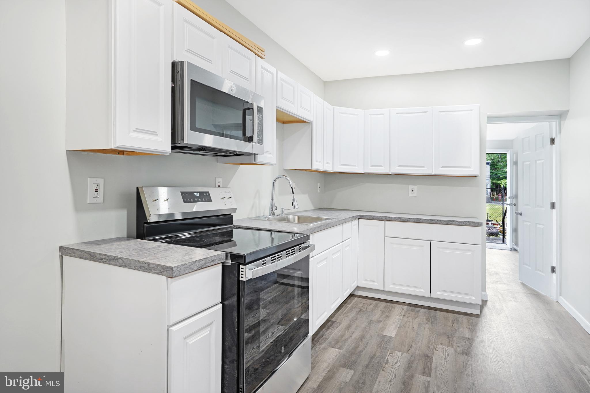 565 Line Street Camden, NJ 08103 - Photo 9 of 31 a kitchen with stainless steel appliances granite countertop a sink a stove a microwave and cabinets