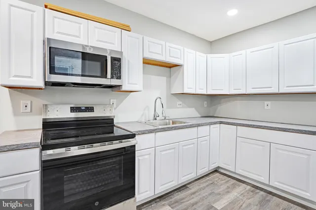 a kitchen with cabinets stainless steel appliances and a sink