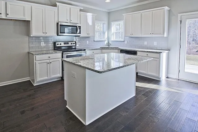 a kitchen with stainless steel appliances granite countertop a sink stove and microwave
