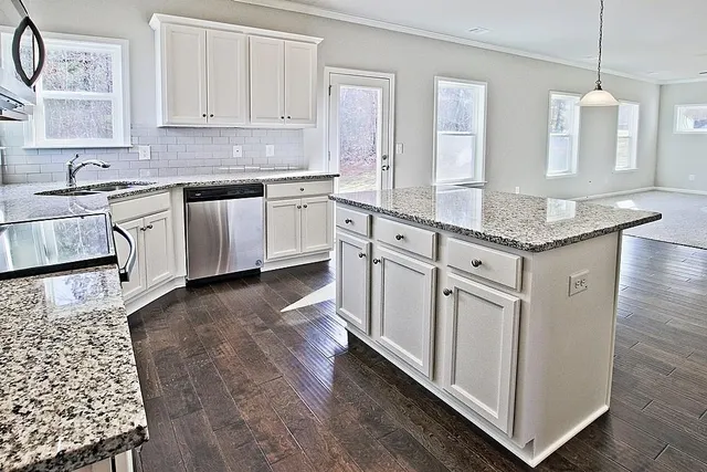 a kitchen with stainless steel appliances granite countertop a sink stove and cabinets