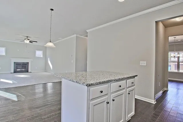 a kitchen with granite countertop a sink cabinets and wooden floor
